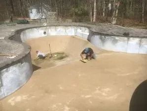 A couple of men are working on a swimming pool.