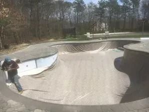 A man is riding a skateboard in a large pool.
