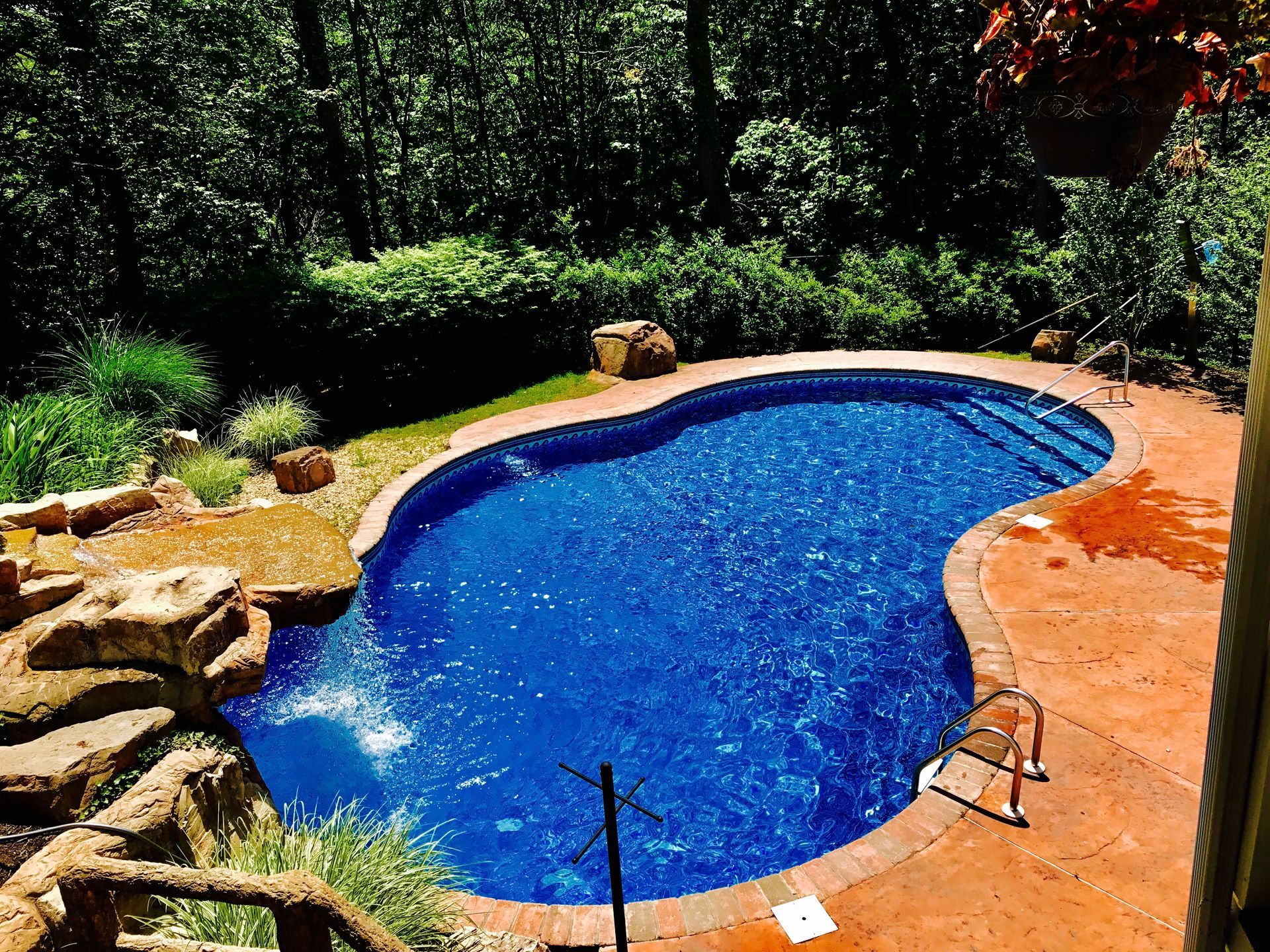A swimming pool with a view of the ocean and palm trees