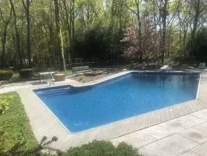 A blue net is being used to clean a swimming pool.