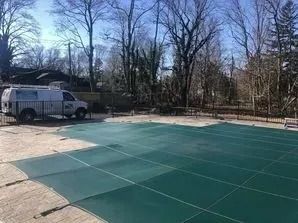 A van is parked on the side of a swimming pool.