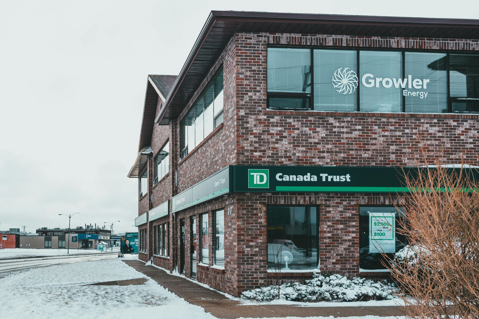 A brick building with a green sign that says canada trust on it.