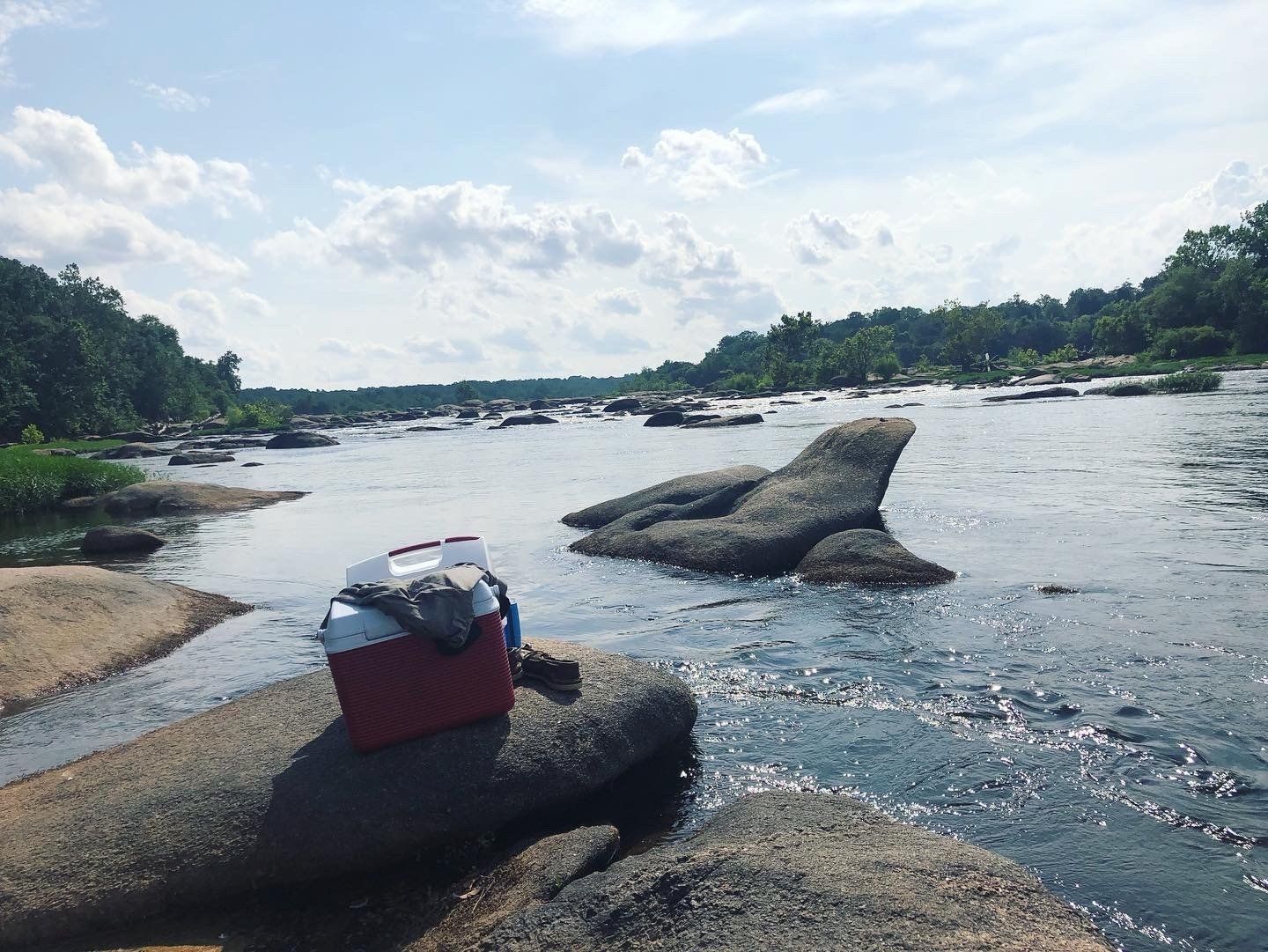 Image of James River from rock vantage point, with a cooler in foreground. Image captured by RETEX's Katelyn Lewis.