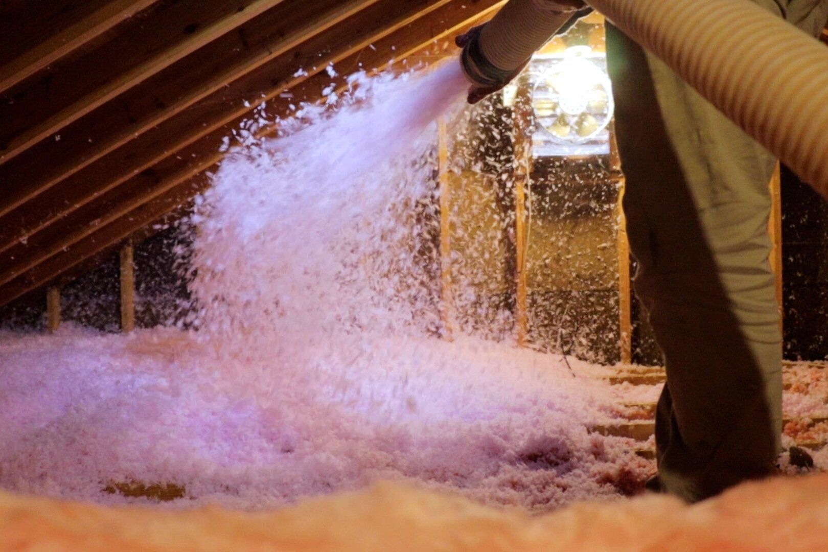 An image of a laborer installing insulation in a North Chesterfield home's attic space.