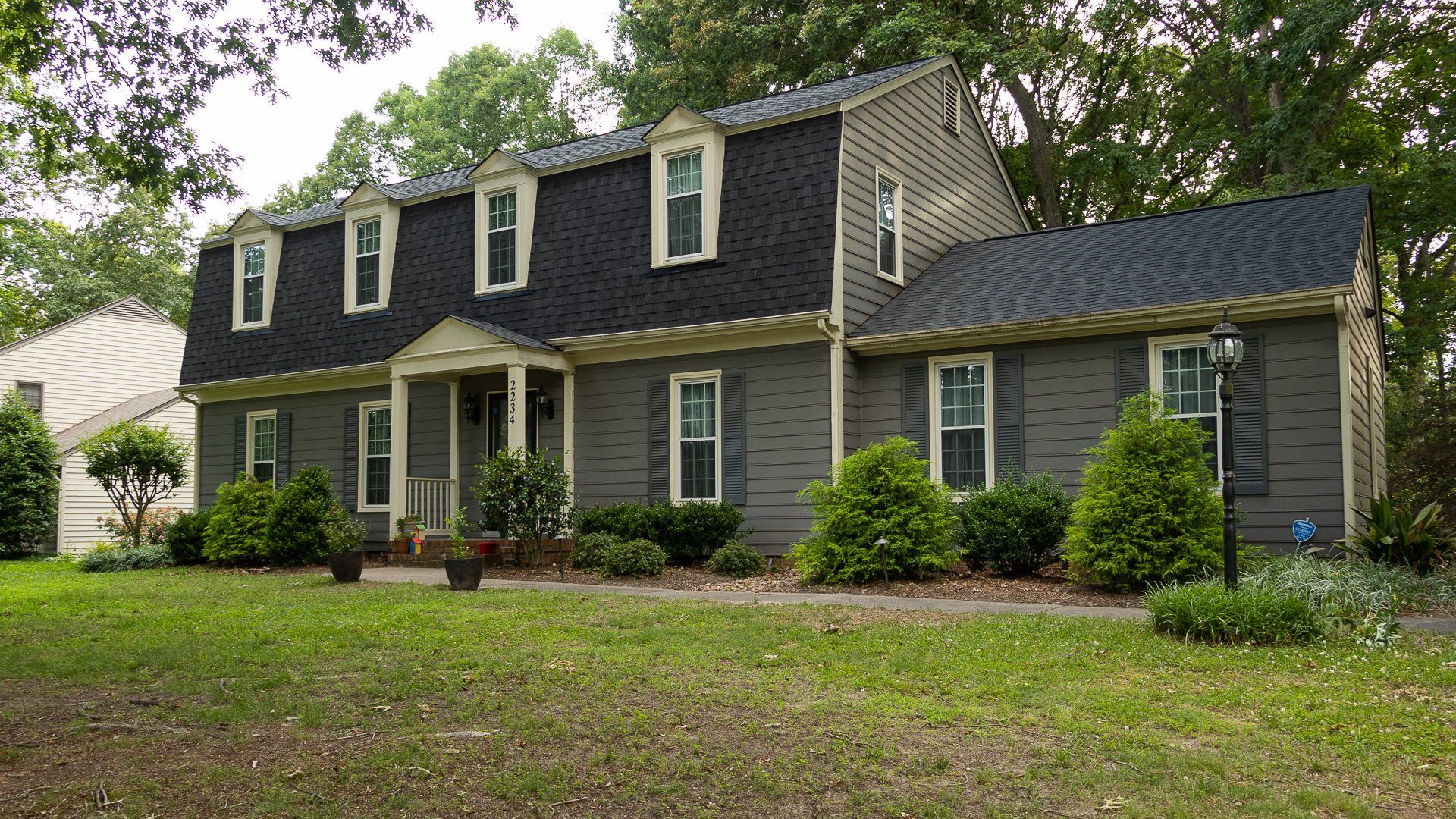 Front-of-home image of a North Chesterfield home where RETEX crew members are installing a new asphalt shingle roof.