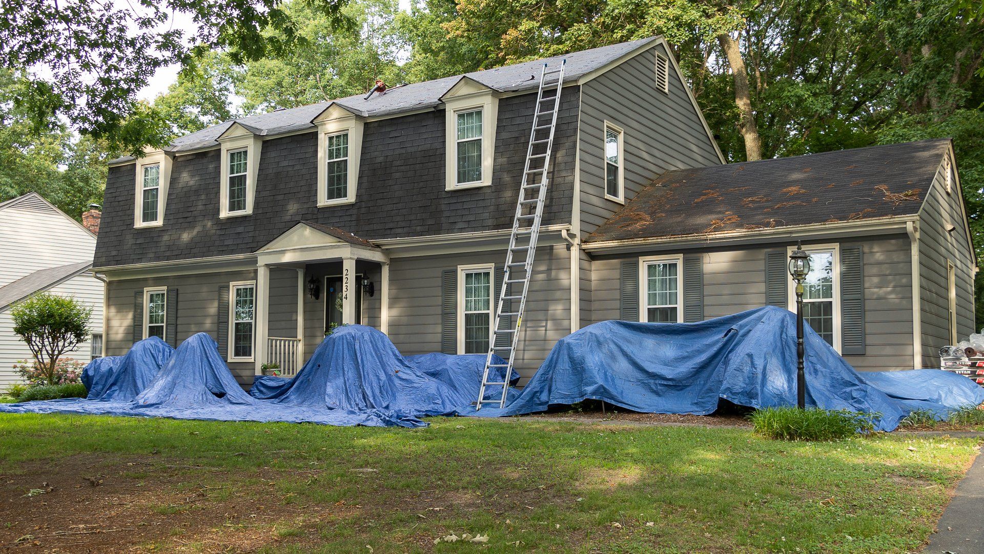 Front-of-home image of a North Chesterfield home where RETEX crew members are installing a new asphalt shingle roof.