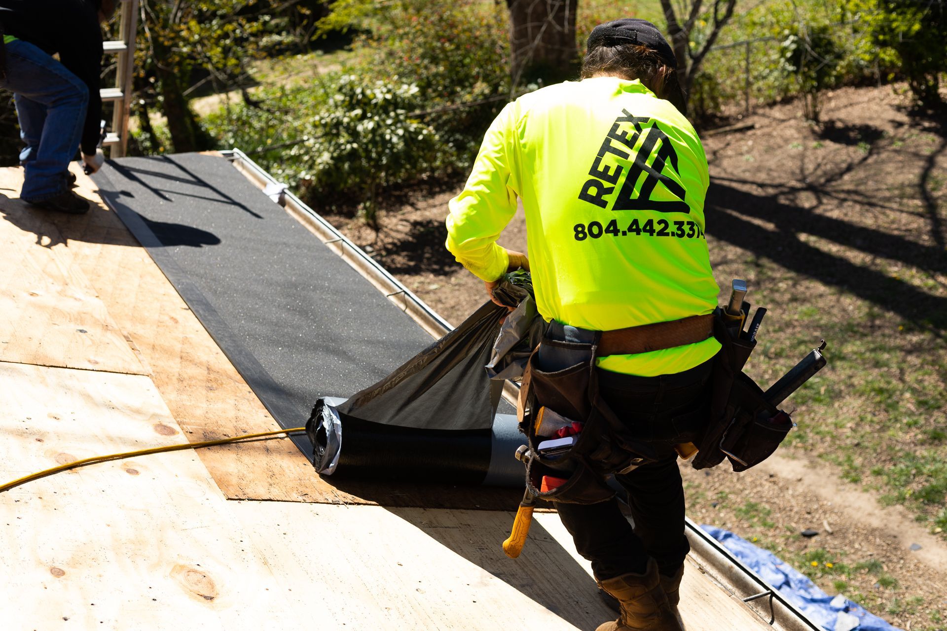 Image of crew member installing underlayment during roof replacement in North Chesterfield VA. By RETEX's Katelyn Lewis.