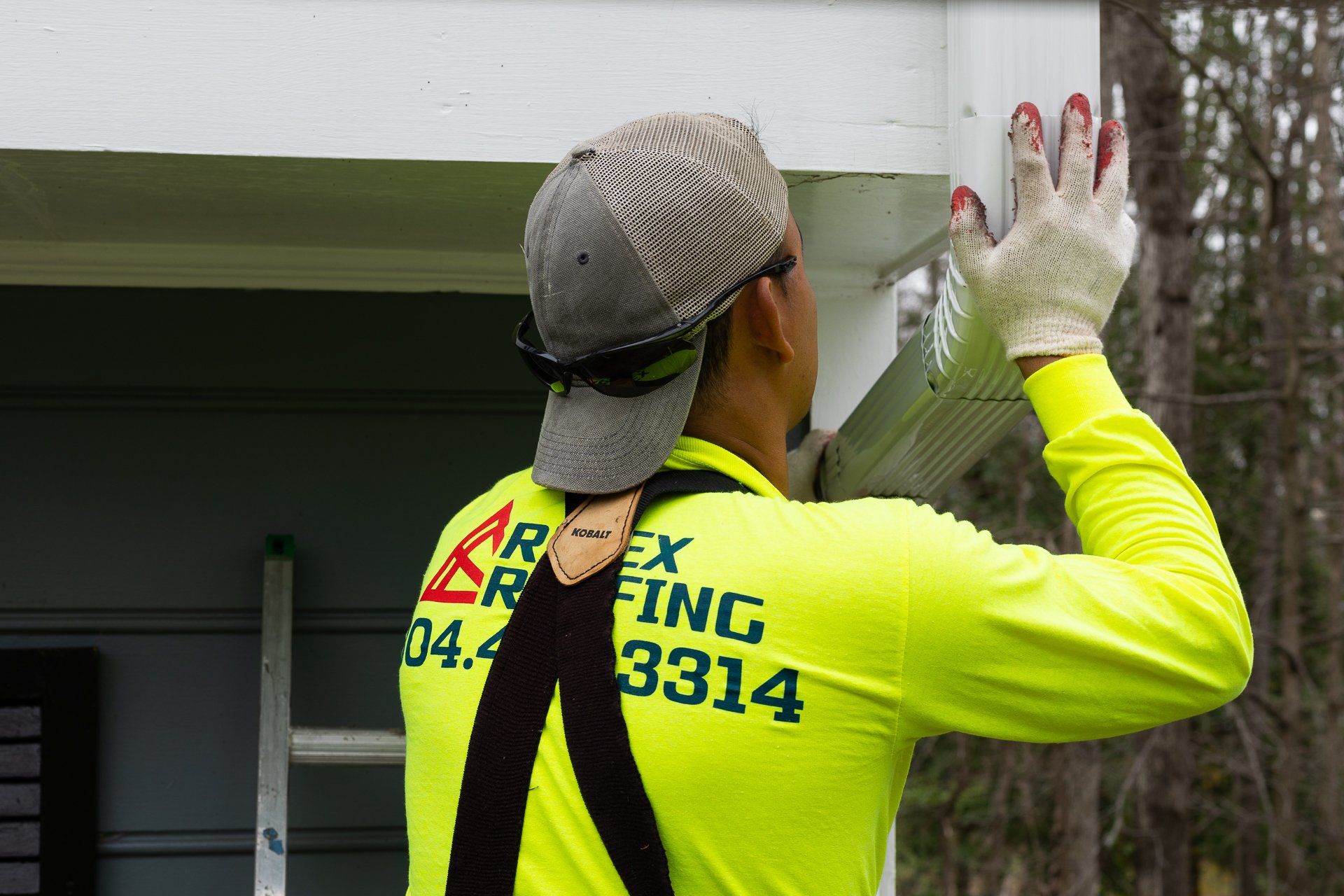 Image of a RETEX crew member installing a downspout on a Plygem gutter system for a North Chesterfield VA home.