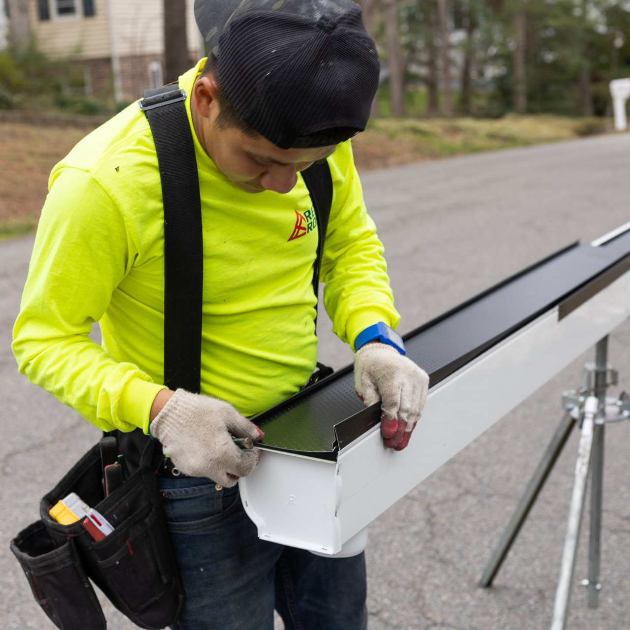 Image of RETEX a crew member installing gutter guards on a Plygem gutter system for a North Chesterfield VA home.