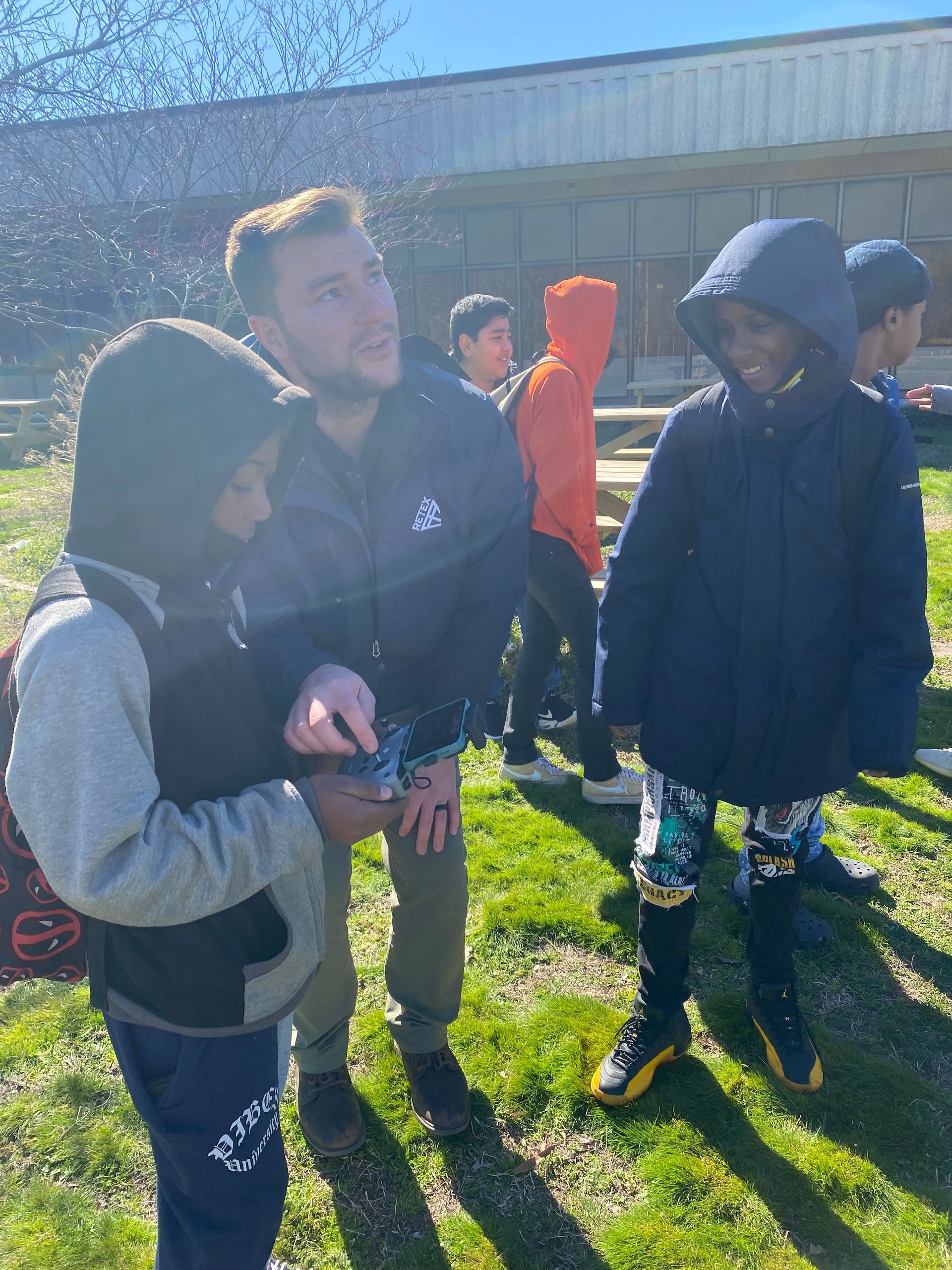 Image of RETEX's Josh Lewis teaching local 7th graders how to fly a drone.