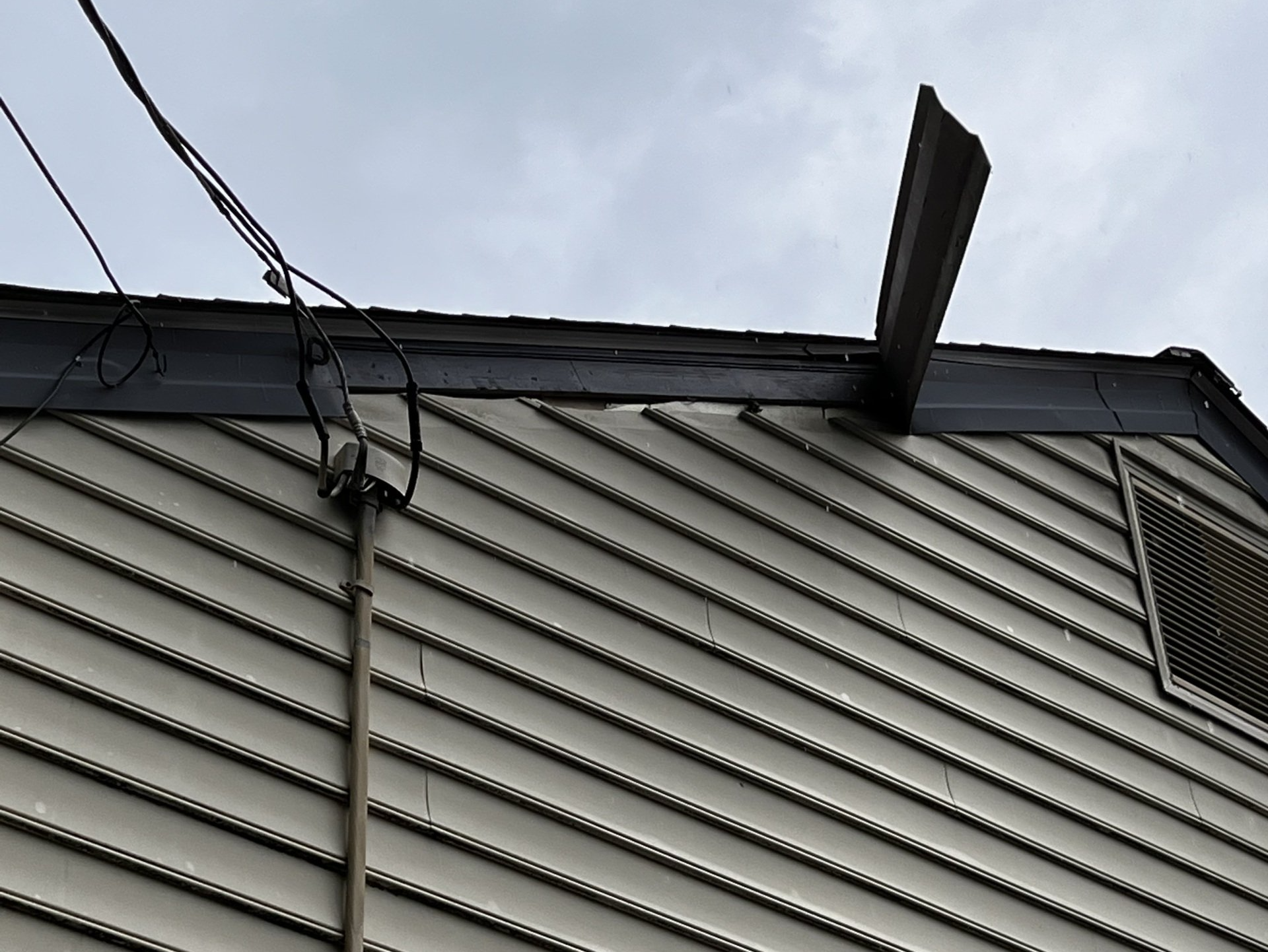Image of aluminum trim cladding, the fascia covering, pulling away from a home.