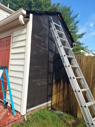 A during-install photo of a fire-damaged shed that RETEX replaced the siding, roof, and gutters for in Glen Allen VA.