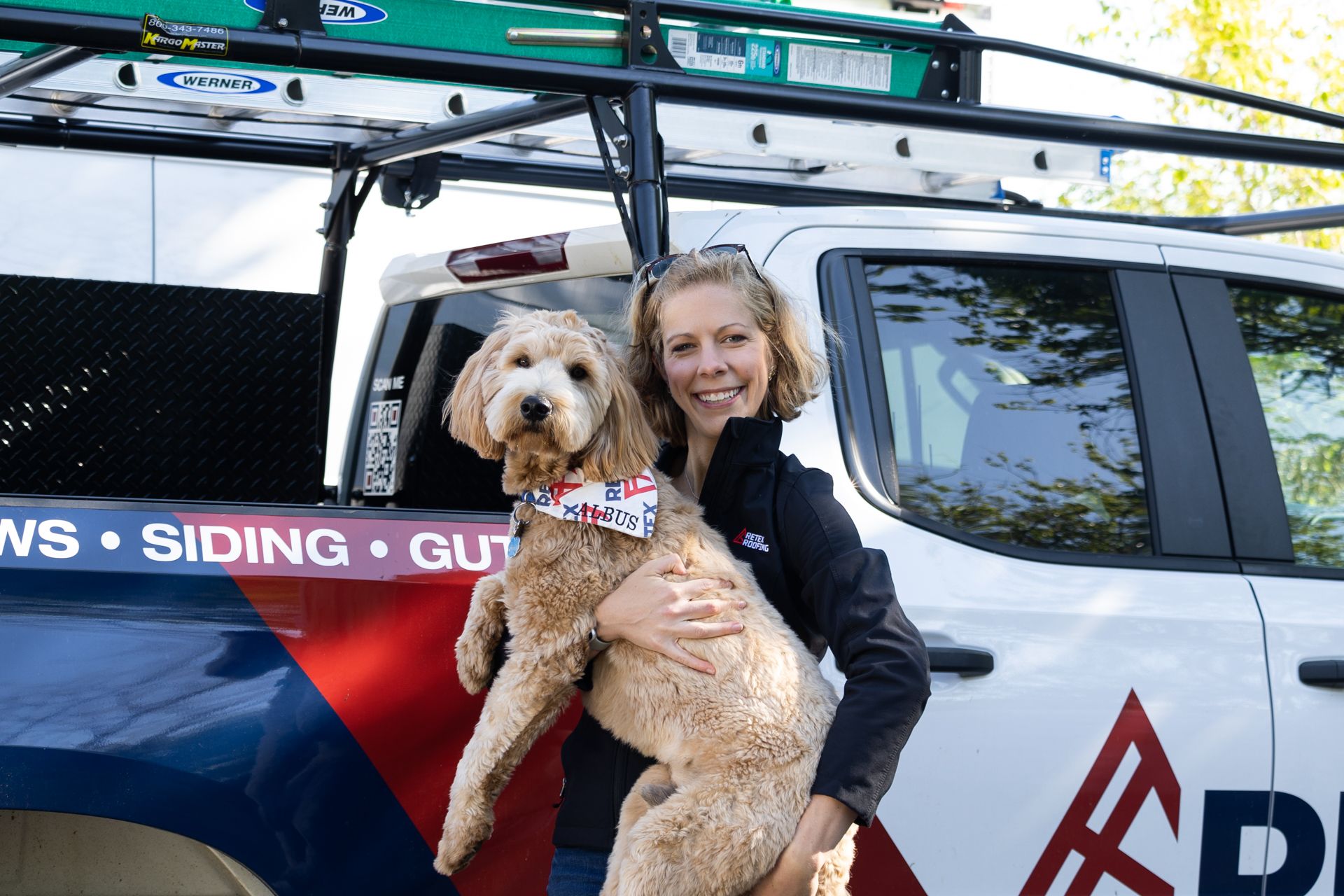 A portrait image of RETEX's Katelyn Lewis holding Albus Lewis in front of a RETEX truck.