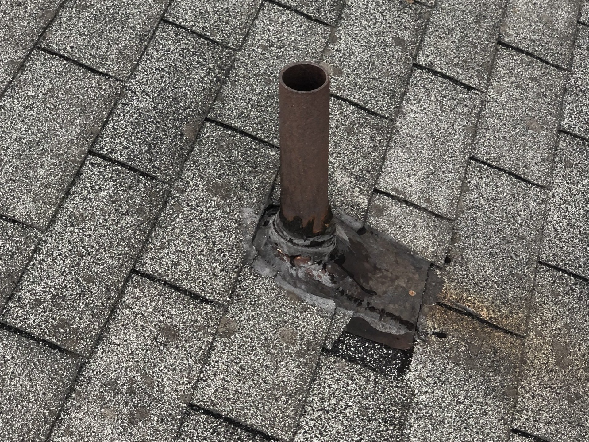 Image of an old, cracked pipe boot on an old asphalt shingle roof in Richmond, VA.