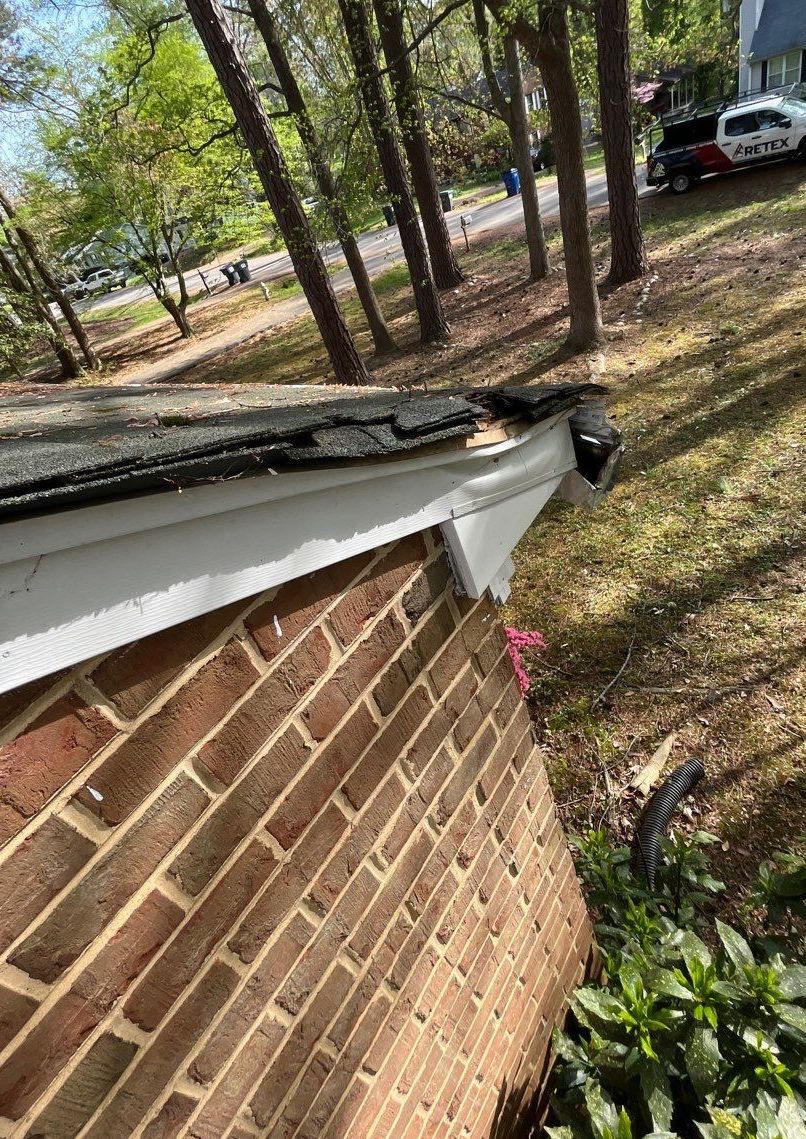 Image of tree damage on an old asphalt shingle roof in Richmond, VA.