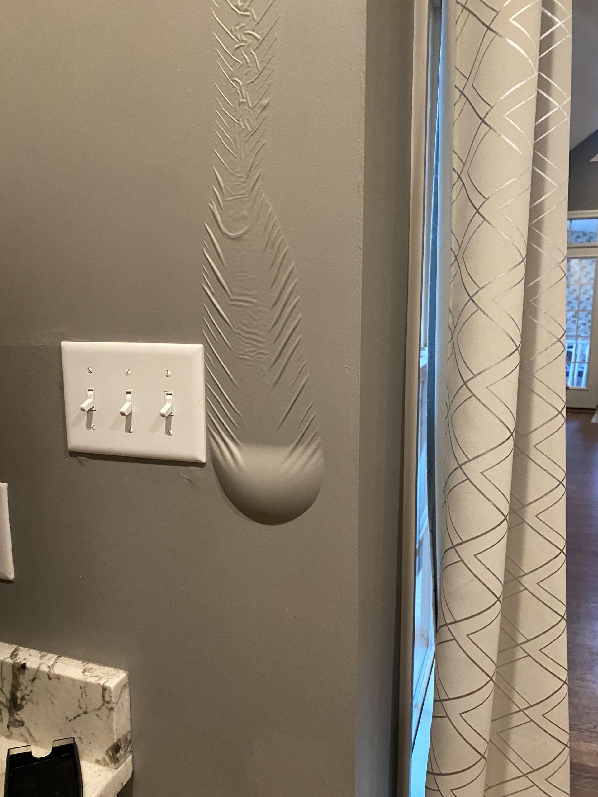 An image of water damage pooling into a bubble on aa homeowner's drywall inside their home.