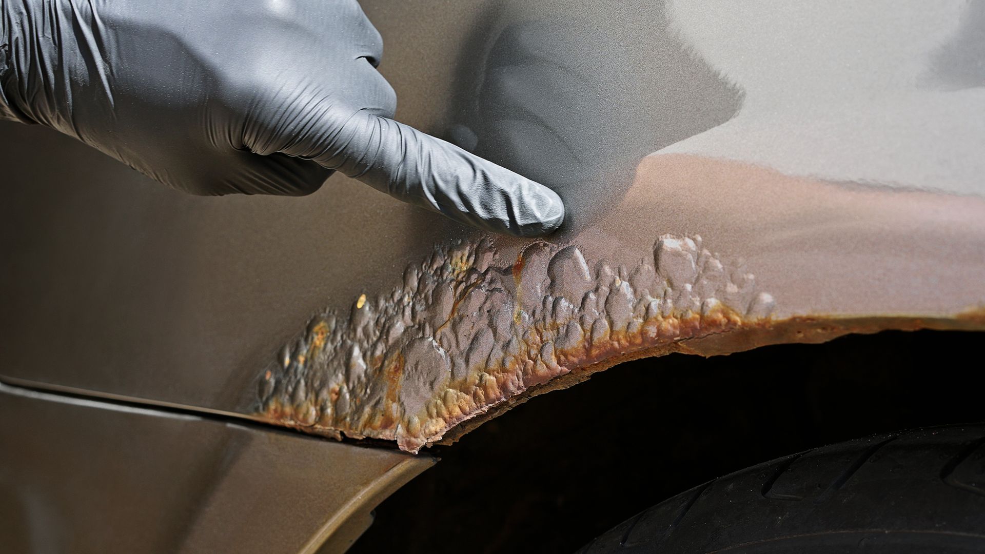 Severe automotive rust on a car wheel arch panel.