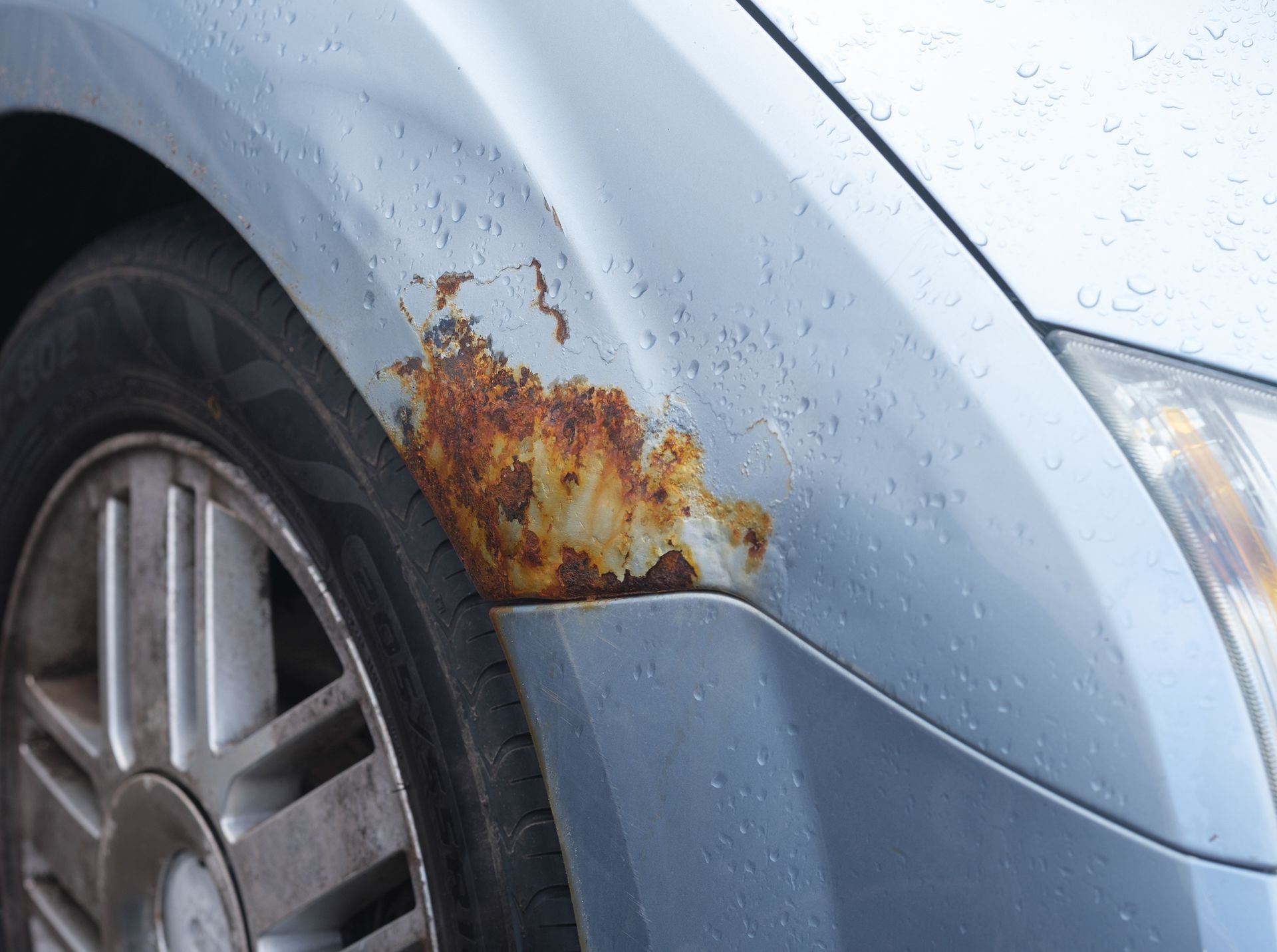 Rust patch forming on the wheel arch of a modern car, showing early signs of corrosion damage