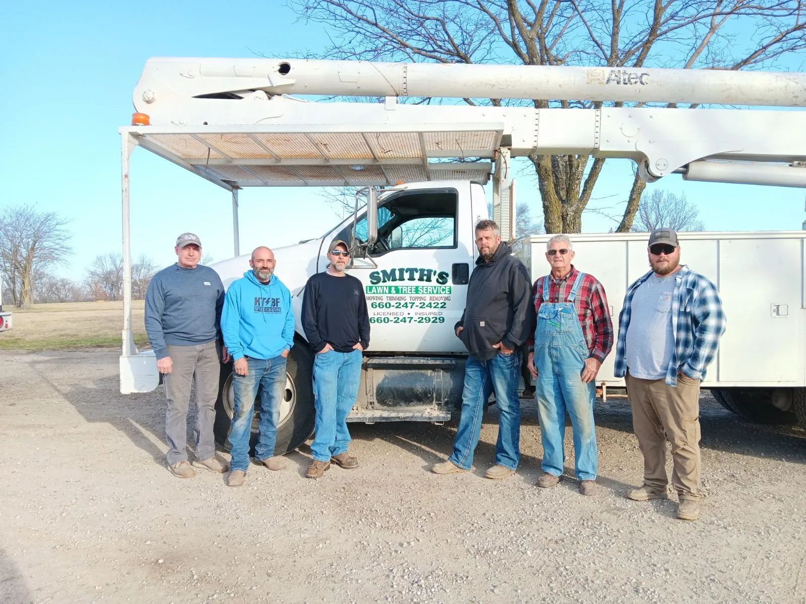 a group of men are standing in front of a utility truck