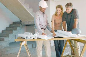 a contractor discussing the house plan with the couple