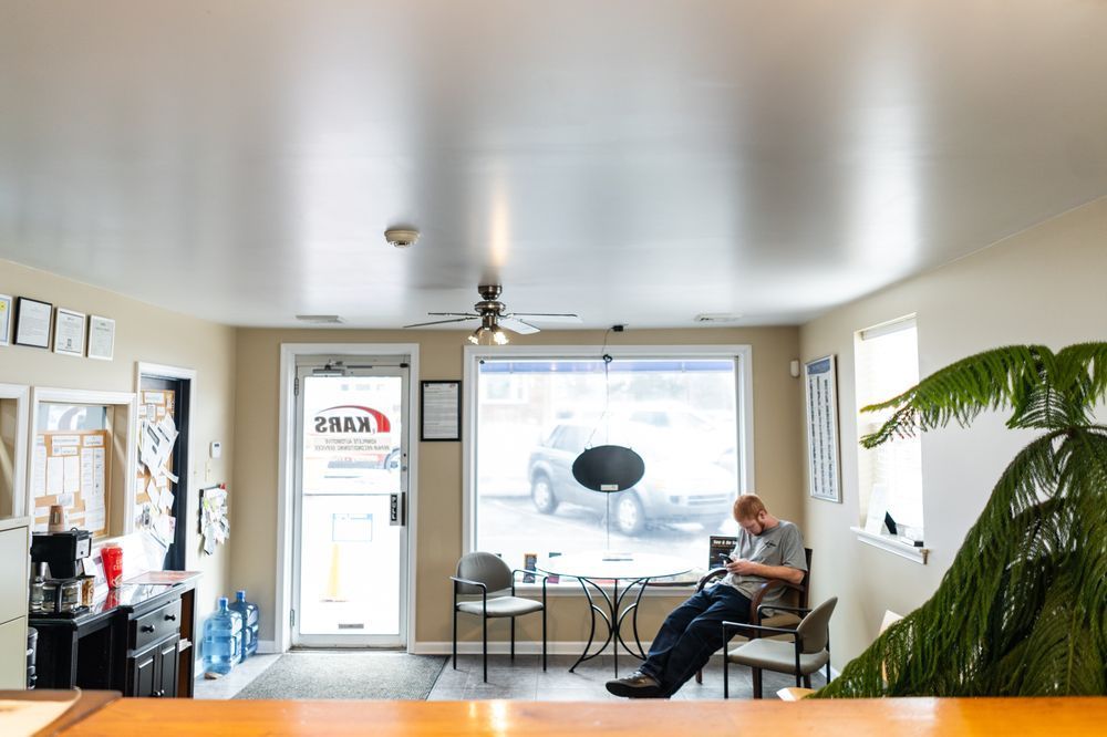 A man is sitting in a waiting room looking at his phone.