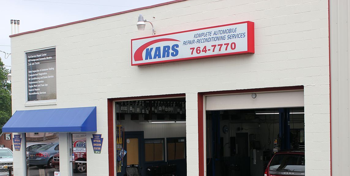 A white building with a red sign that says kars