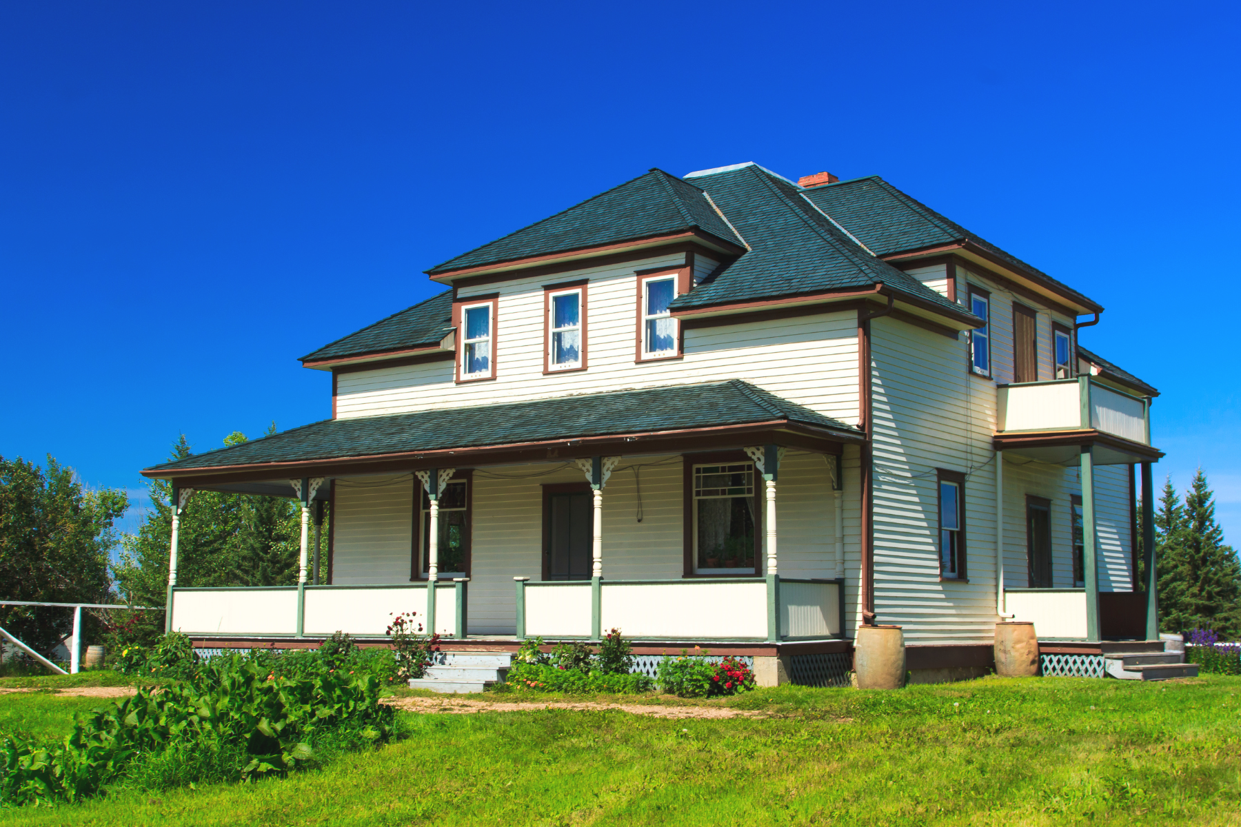 A white house with a green roof and a porch