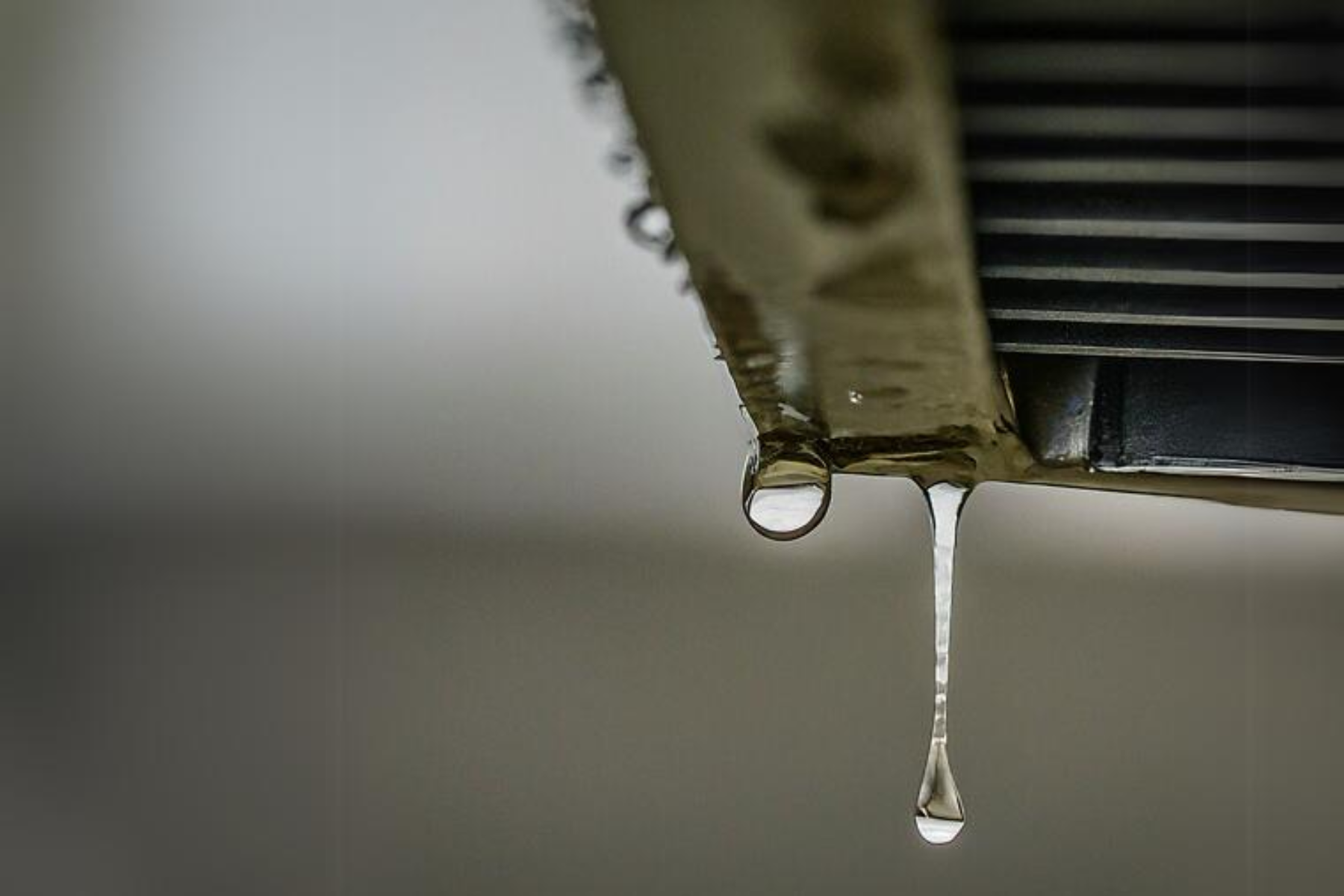 A close up of a drop of water coming out of a air vent.