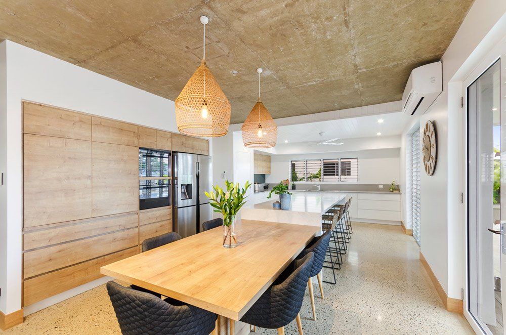 Pallarenda Beach House Kitchen with Wooden Tables and Chairs — Award-Winning Builders in Townsville, QLD