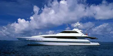 White yacht on the water under a partly cloudy, blue sky.