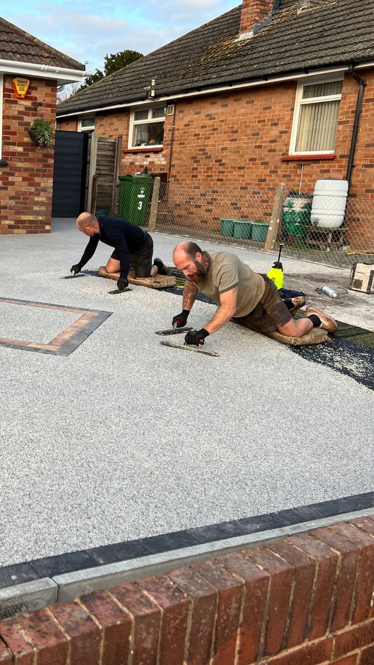 A photo of 2 workers laying the fresh grey resin