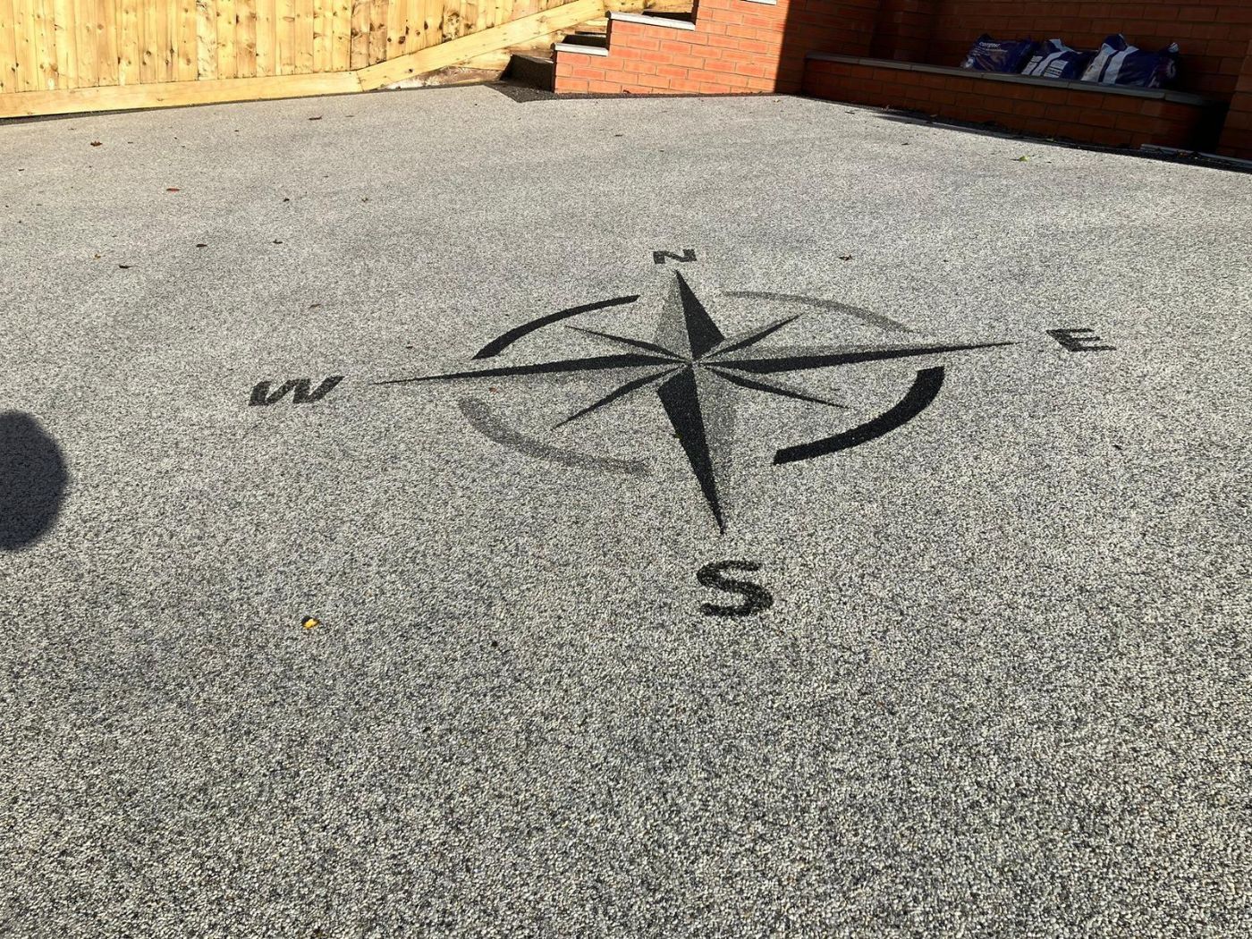 Close up of compass pattern on a grey resin driveway