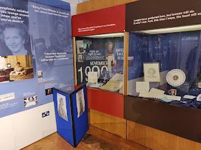 A room with a lot of display cases and posters on the wall.