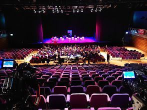 A large empty auditorium with purple seats and a stage.