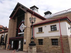 A large brick building with a red roof and a lot of windows.