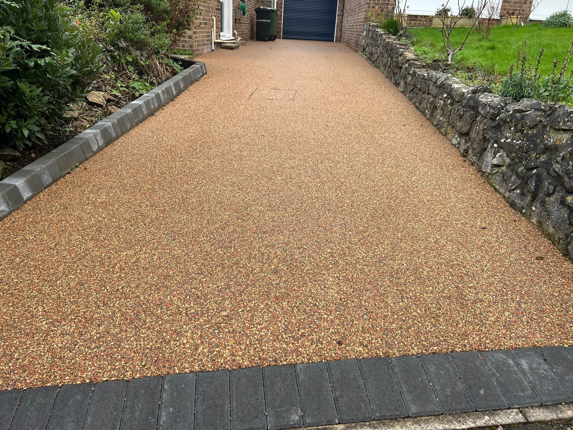 A gravel driveway leading to a house with a garage door.