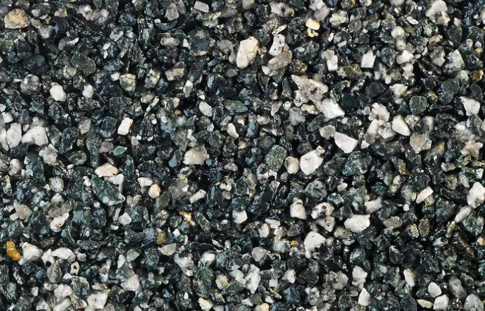 Close-up of dark gravel with gray and white stones scattered across the surface