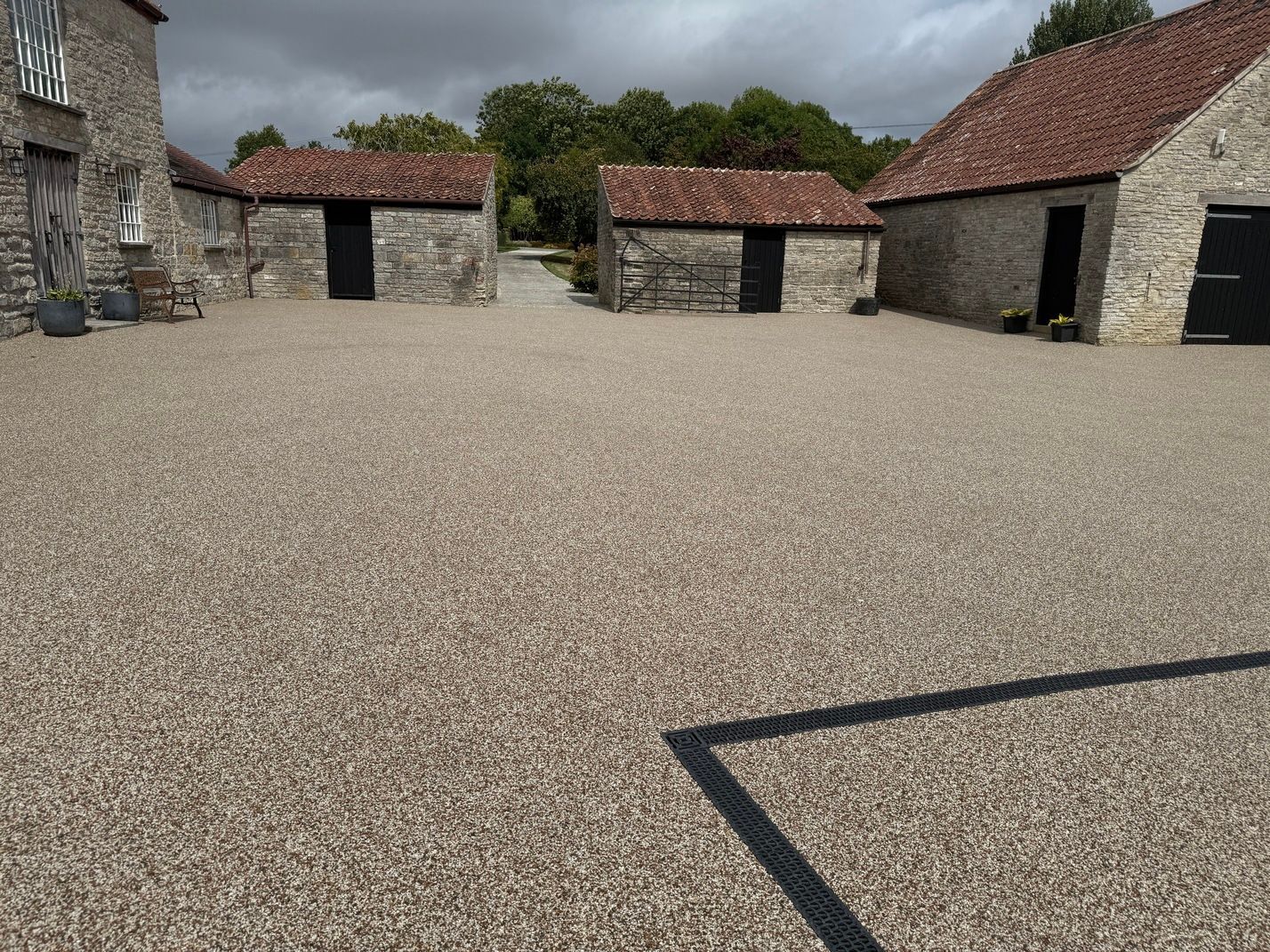 Light resin driveway with two wooden gates open 