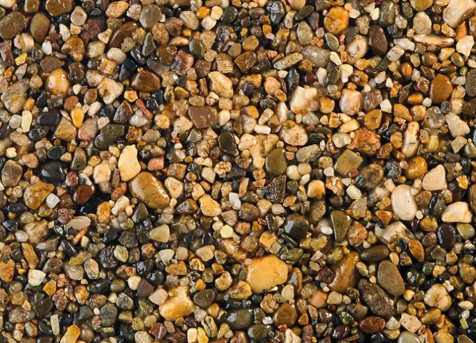 Close-up of multicolored pebbles and gravel, with tan, gray, black, and amber stones.