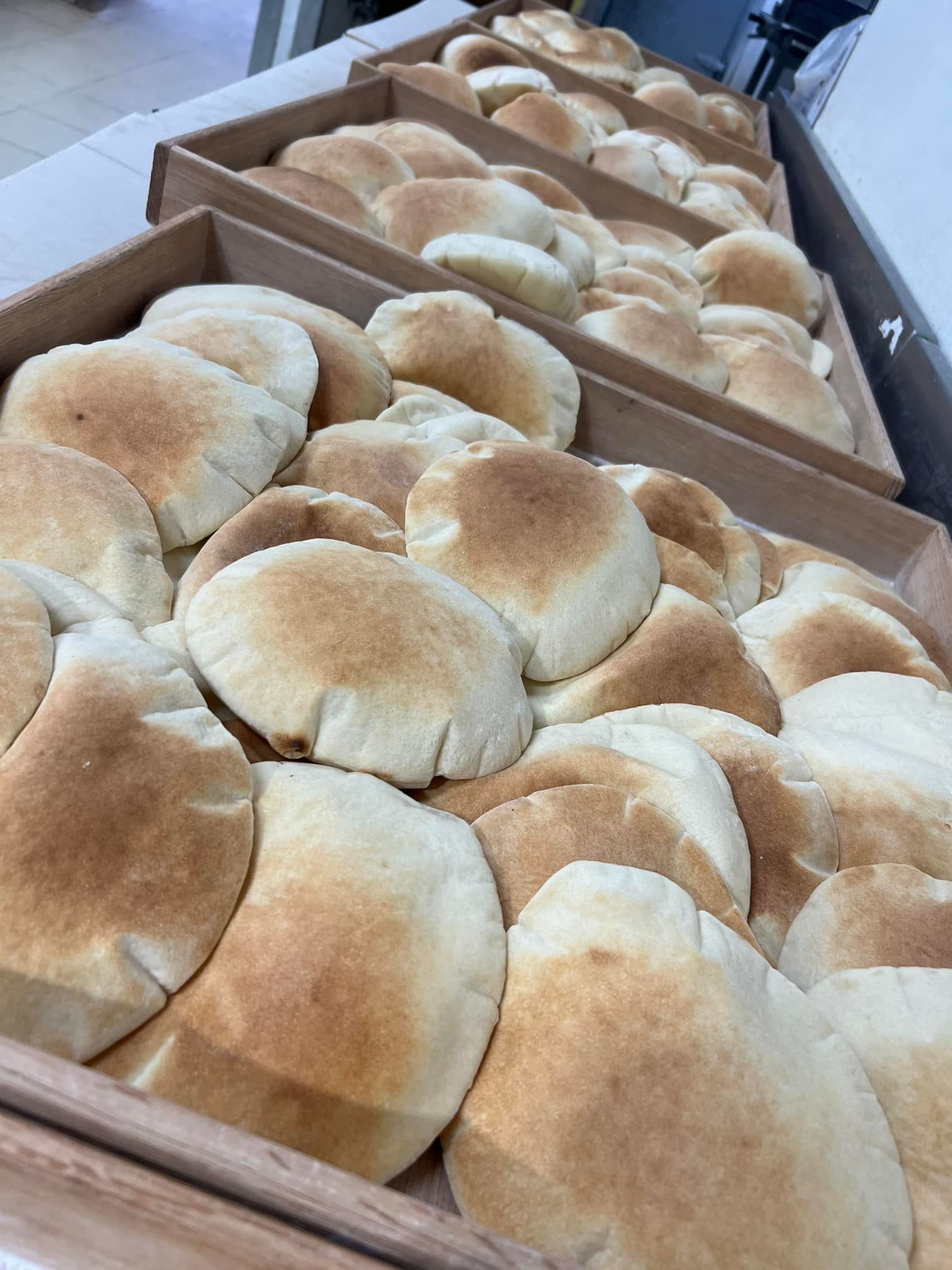 A tray of pita bread is sitting on a table.