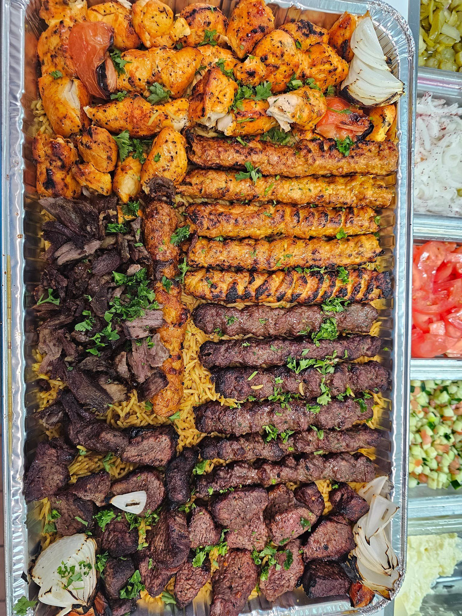A large tray filled with lots of different types of meat and vegetables.