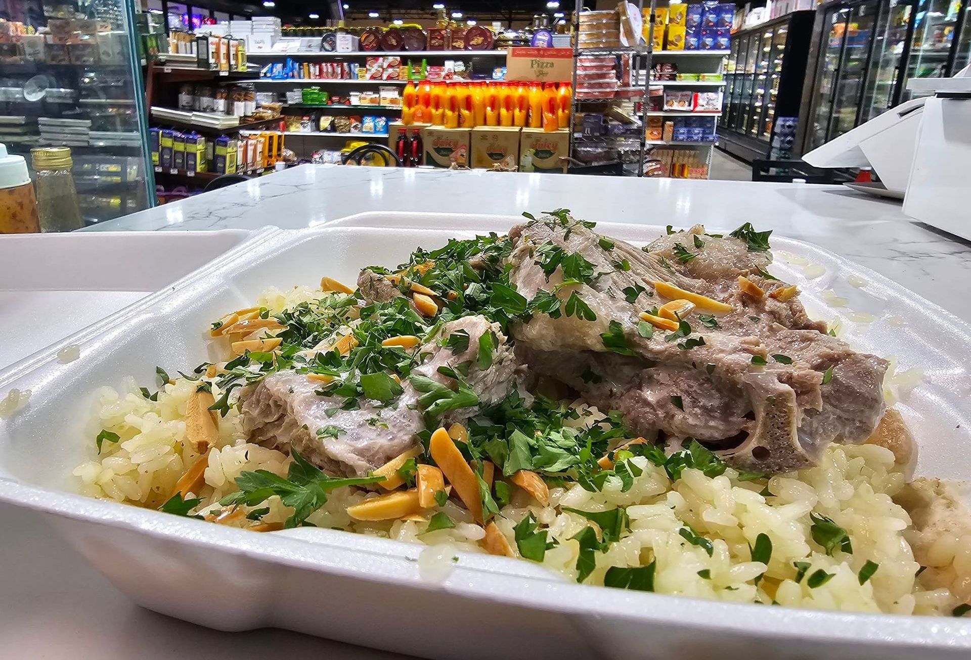 A styrofoam container filled with food is sitting on a table in a store.