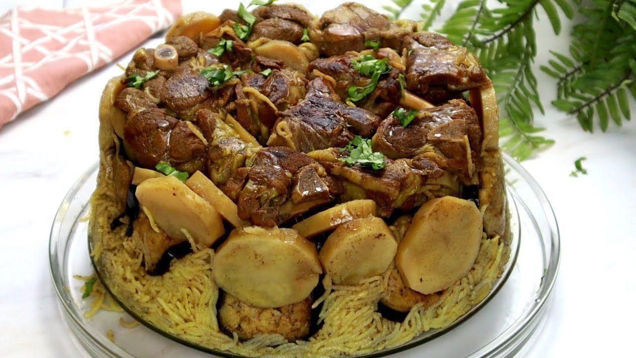 A close up of a plate of food with meat and potatoes on a table.