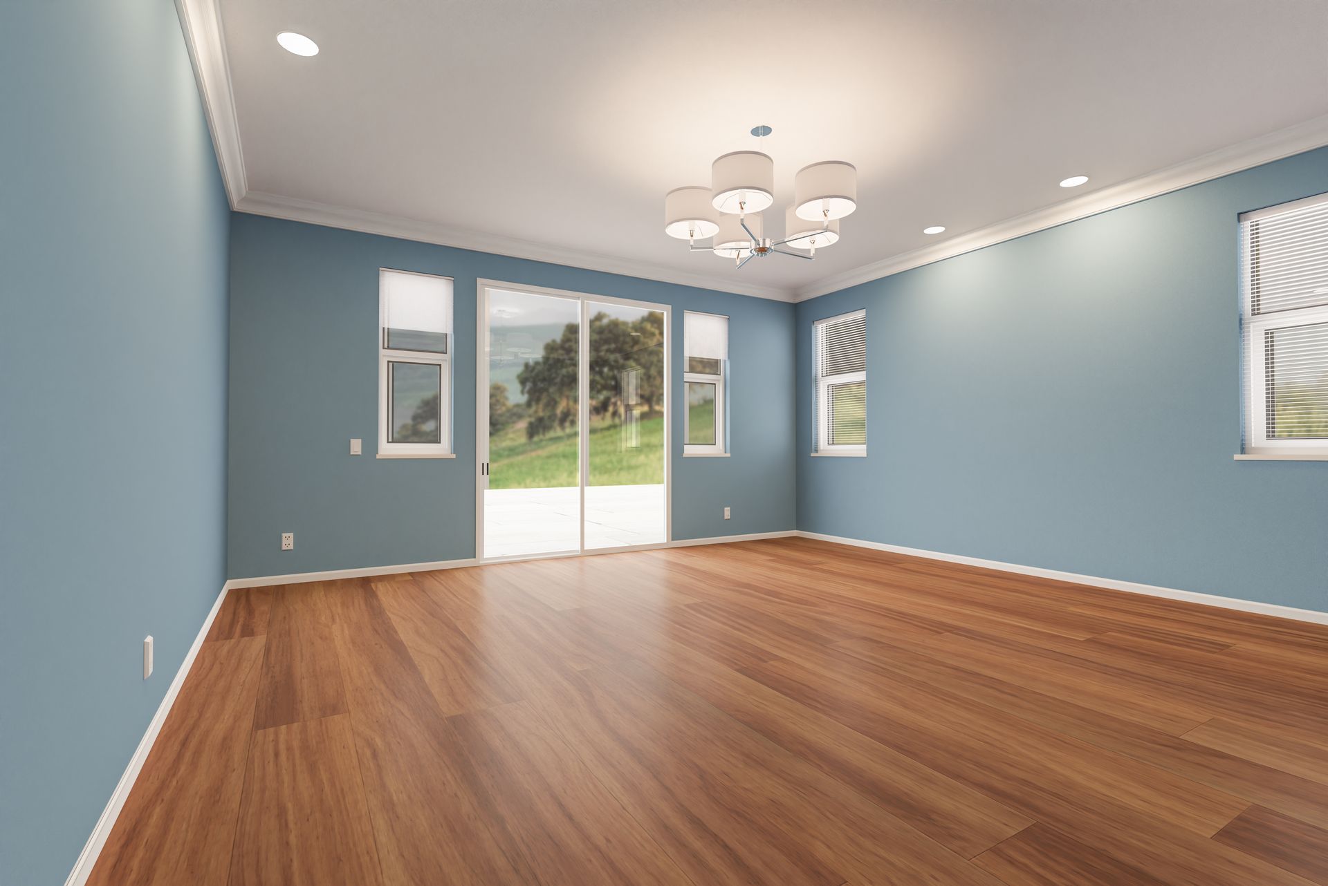 Empty blue living room with hardwood floors, recessed lights, and sliding glass doors to a yard