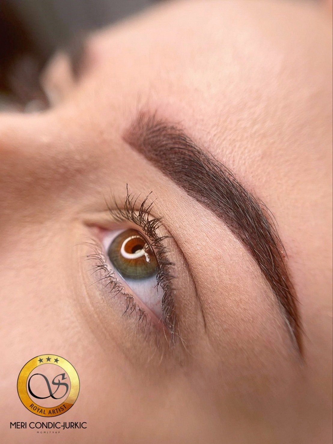 Eine Nahaufnahme des Auges einer Frau mit brauner Augenbraue.