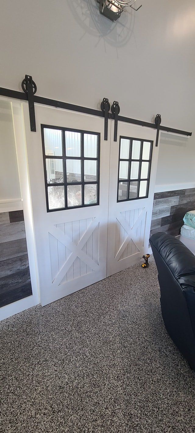 A living room with a sliding barn door and a couch.