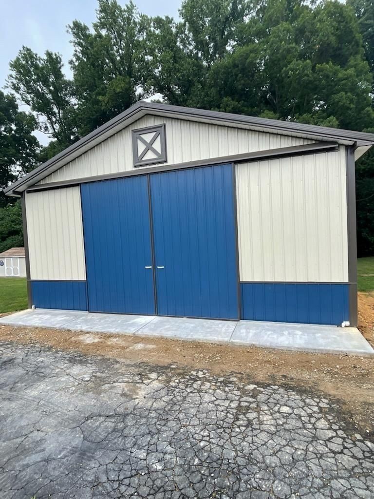 A white and blue barn with a sliding barn door.