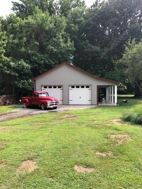 A red truck is parked in front of a garage.