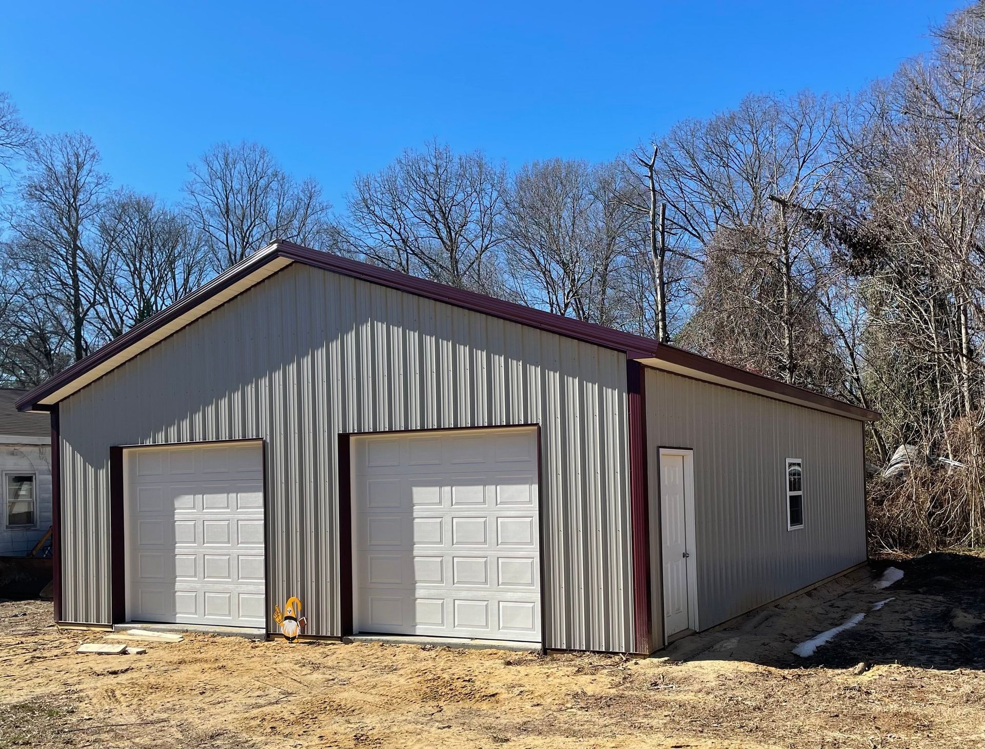 A large metal building with two garage doors and a window.