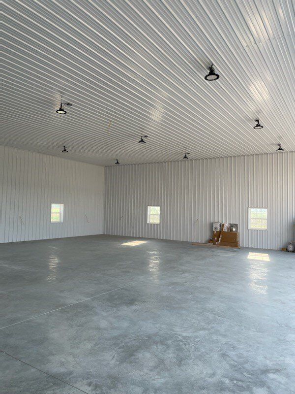A large empty building with a concrete floor and white walls.